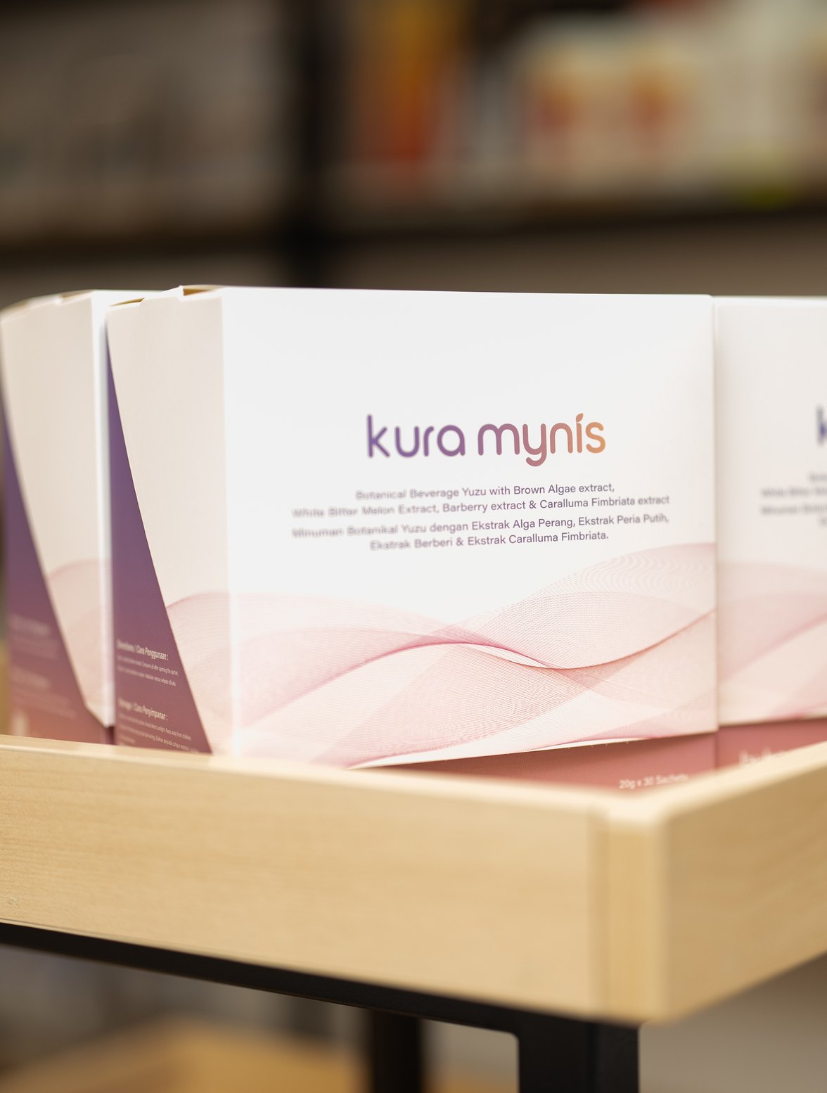 Kura Mynis 30-sachet boxes on a pharmacy display table