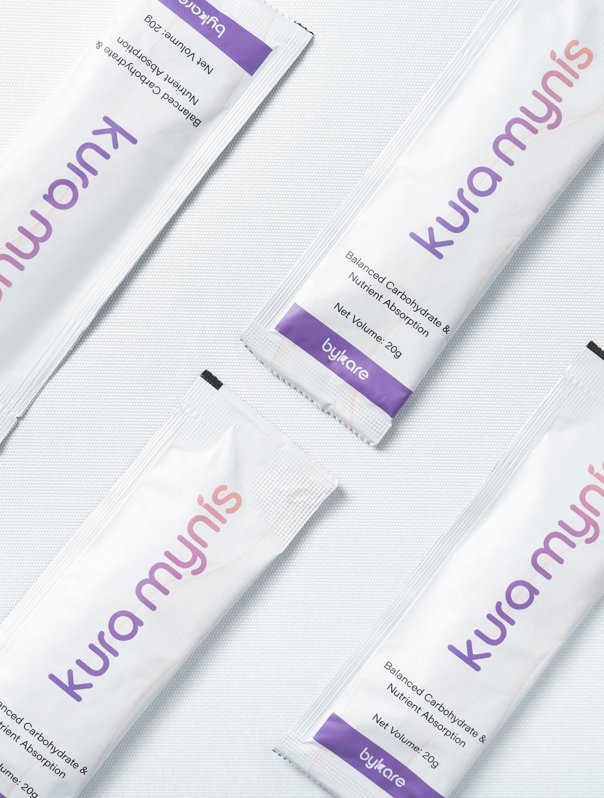 Four Kura Mynis 20 g sachets laid flat