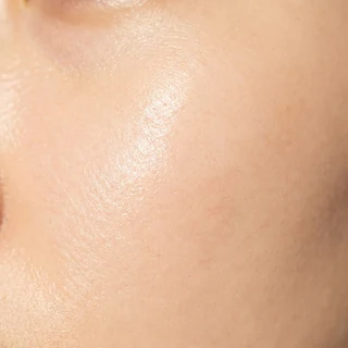 Close-up of luminous even-toned skin catching soft light